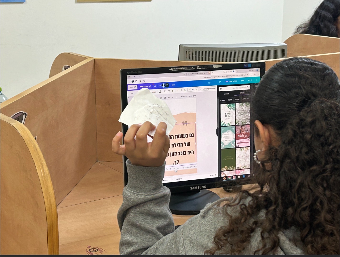 סטודנטית ממשאבי למידה בסדנא מול מסך מחשב צופה במצגת